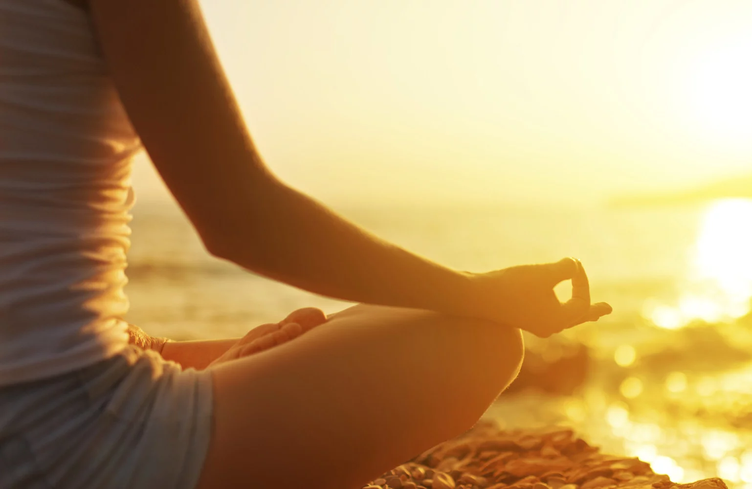 hand of woman meditating in a yoga pose on beach